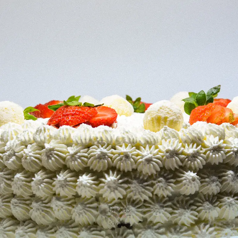 Lateral de bolo confeitado com bicos de chantilly e morangos