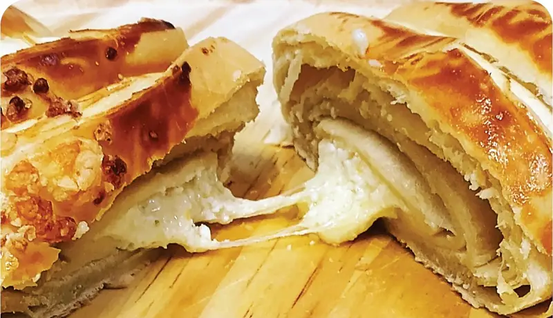 Croissant de 4 queijos aberto com queijo derretido