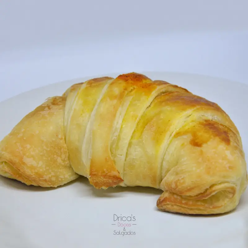 Croissant folhado dourado servido em prato branco