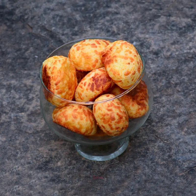 Taça de vidro cheia de pães de queijo gratinados